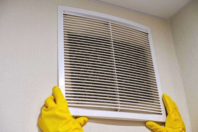 Holding ventilation grill of HVAC for cleaning or replacing.