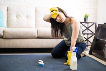 Tired housewife cleaning carpet